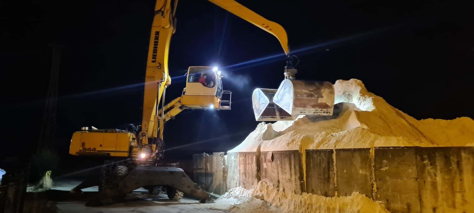Koparka przeładunkowa formująca hałdę materiału sypkiego nocą